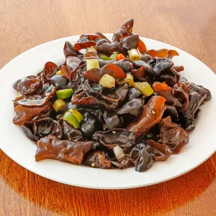 a white plate of chili bistro on a wooden table