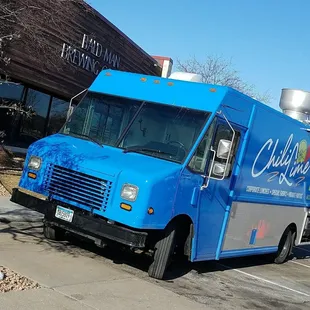 a blue food truck parked in a parking lot