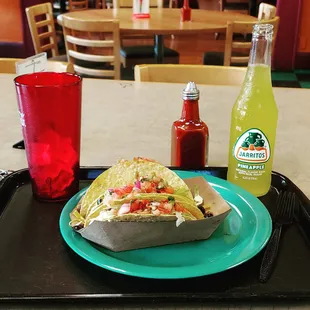 a taco and a drink on a tray