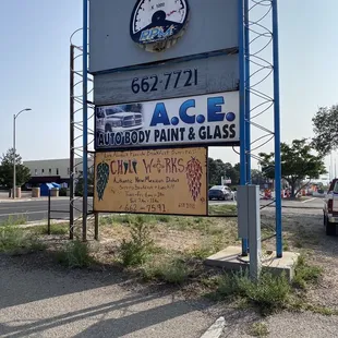 a sign for ace auto body paint and glass