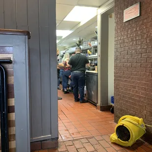 Girl with loose hair receiving customers orders and manager aside her