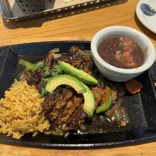 a plate of mexican food with rice and avocado