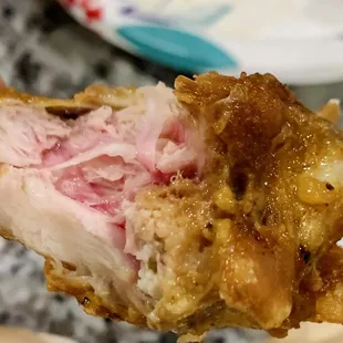 a hand holding a piece of meat