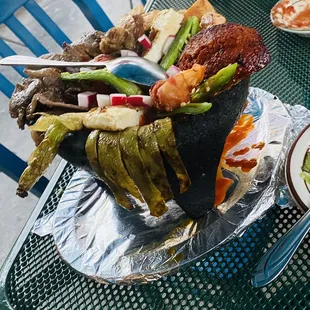 Molcajete with nopales, shrimp, chicken, beef, cheese, chorizo, bell peppers and more.