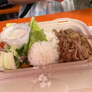 a take out container with rice, meat and vegetables