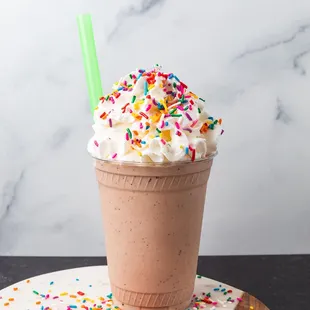  a chocolate milkshake with sprinkles and a green straw