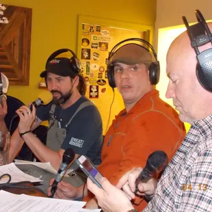 a group of men sitting at a table with microphones