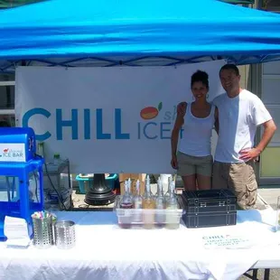 a man and a woman under a blue tent