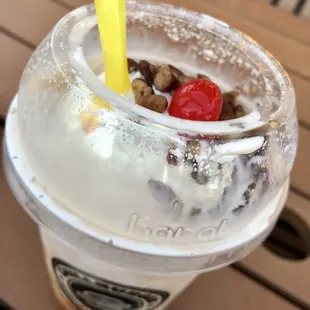 a cup of ice cream with a cherry on top