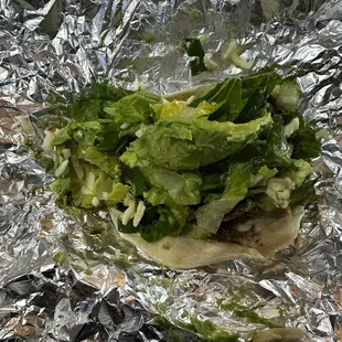 Barbacoa taco with avocado and other toppings, packed up!