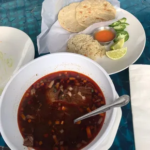 Birria de res soup. (Beef Birria soup.) Comes with rice, limes, and homemade tortillas.