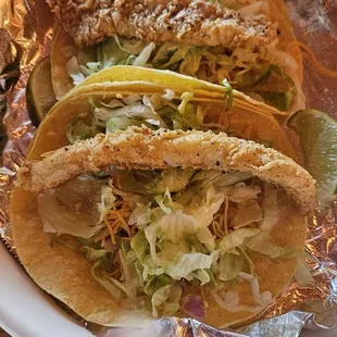 Fish tacos with onion, cheese, &amp; lettuce