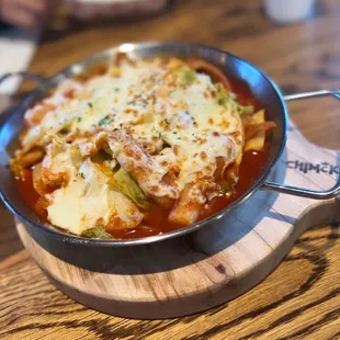a skillet of food on a wooden table