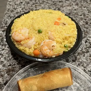 a plate of rice with shrimp and carrots