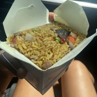 a person holding a box of noodles