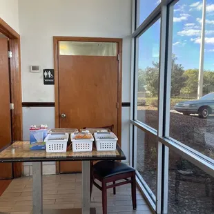 a table with baskets of food in front of a window