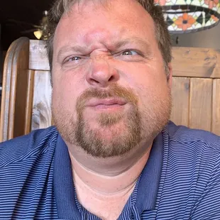 a man in a blue shirt sitting at a table