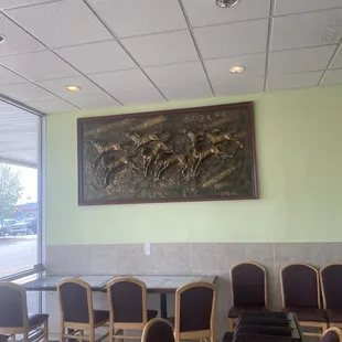 a waiting room with chairs and a painting on the wall
