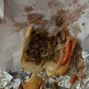 a half eaten sandwich on tin foil