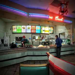 a man standing at the counter of a restaurant