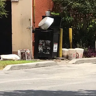 a trash can and trash cans on the side of the road