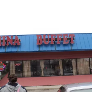 a man standing in front of a chinese restaurant