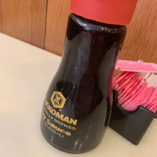 a black bottle with a red lid and a pink lid