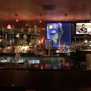 a bar with a large screen in the background