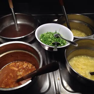 a variety of soups being prepared