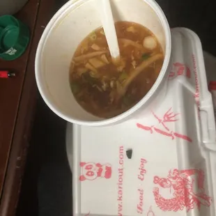 a bowl of soup in a styrofoam container