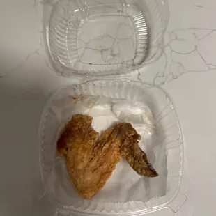 a fried chicken in a plastic container