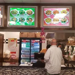 a man standing in front of a restaurant counter