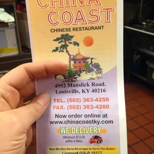 a hand holding a menu for a restaurant