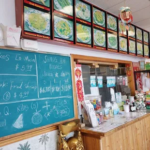 a restaurant counter with menus on the wall