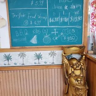 a statue of a buddha in front of a chalkboard