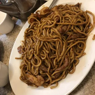 a plate of noodles and meat
