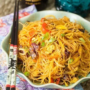a bowl of noodles and chopsticks