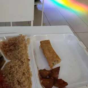 a tray of food with rice, meat, and vegetables