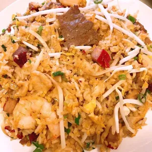 a plate of fried rice with meat and vegetables