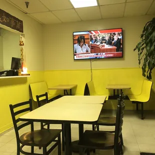 a restaurant with yellow walls and a flat screen tv