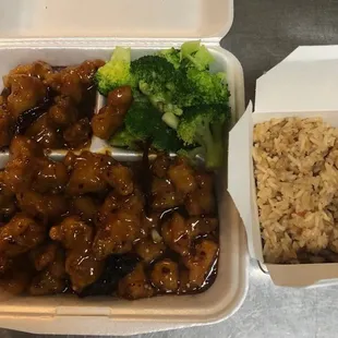 a takeout box with rice and broccoli