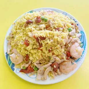 a plate of rice with shrimp and vegetables