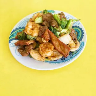 a plate of chinese food on a yellow table