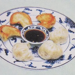 a plate of dumplings and dipping sauce
