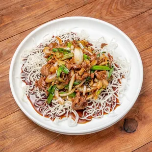 a plate of noodles with meat and vegetables