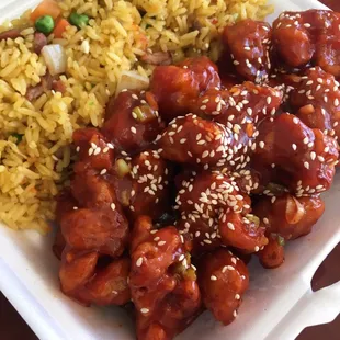 Sesame chicken lunch with fried rice and drink.
