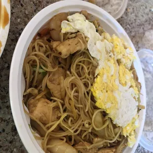 a bowl of noodles with chicken and eggs