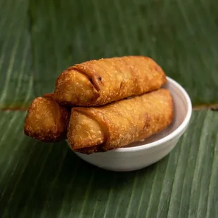 a bowl of fried food on a banana leaf