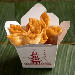 a box of fried food on a banana leaf