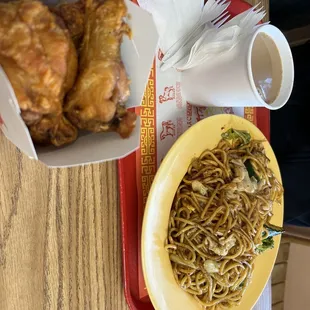 a plate of fried chicken and a bowl of noodles